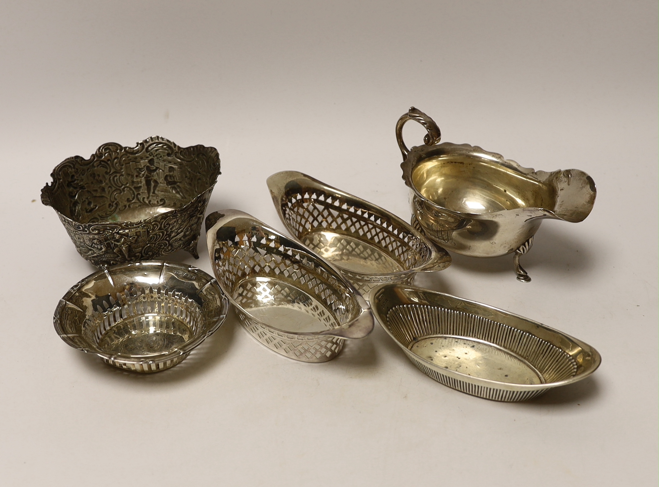 A George V silver sauce boat, three silver bonbon dishes, a small silver bowl and a Hanau white metal bowl.